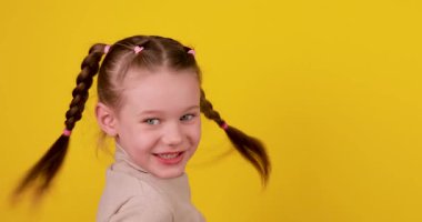 Kızgın bir çocuğun parlak sarı bir arkaplana el salladığı 4K video. Etkileyici agresif davranış, duygusal tepki, hüsran, psikoloji, ebeveynlik ve sosyal konular için öfke nöbeti konsepti.