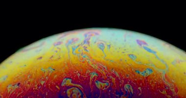 Canlı bir sabun köpüğü büyüleyici bir 4K yakın çekim videosunda zarif bir şekilde süzülür, büyüleyici ve sürekli değişen renkler sergiler. Işık ve yanardöner renklerin narin oyunu büyülü, rüya gibi bir atmosfer yaratır.