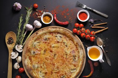 Bir tabak ve pişirme malzemeler İtalyan pizza: yağ, domates, biber, baharat siyah arka plan üzerine