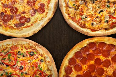 Dört İtalyan pizza karanlık arka plan üzerinde