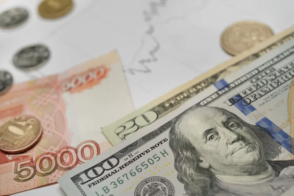 Деньги банкноты доллары и российские рубли с монетой на финансовом графике на белом фоне — стоковое фото