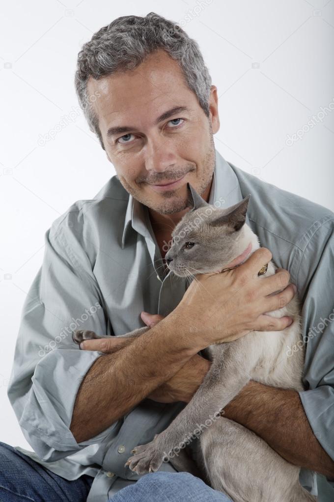 man holding Siamese cat