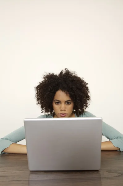 Mujer joven rizado utilizando el ordenador portátil — Foto de Stock