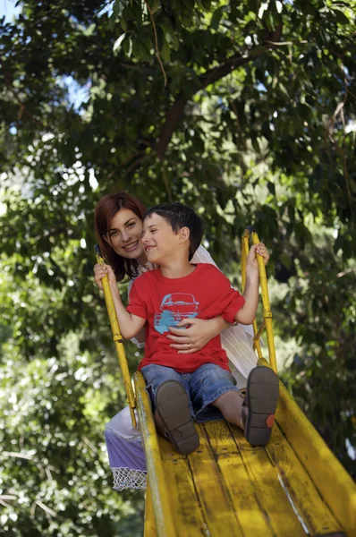 Mãe e filho em slide amarelo — Fotografia de Stock