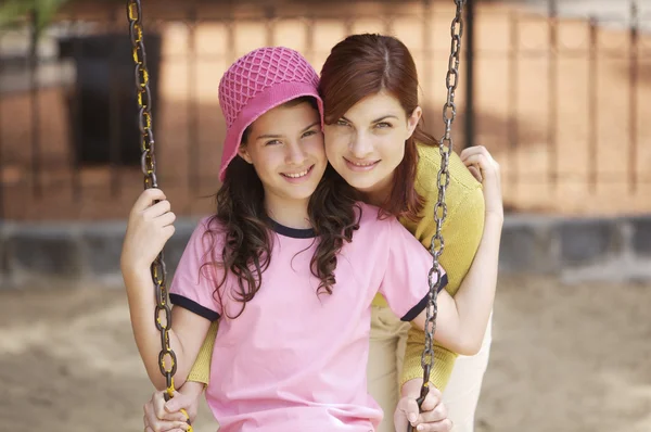 Mother and daughter playing on swing — Stock Photo, Image