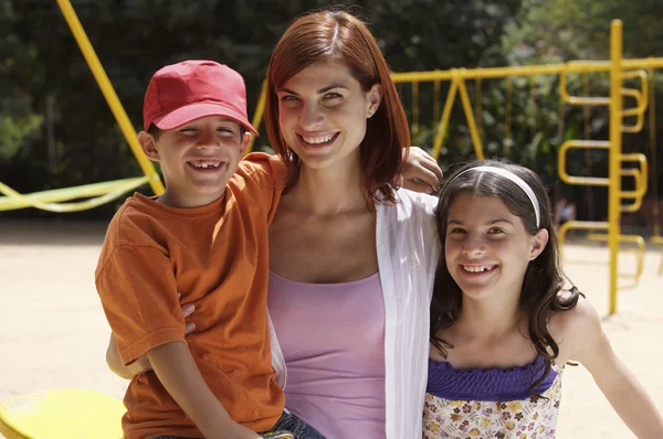 Madre e hijos en el parque infantil — Foto de Stock