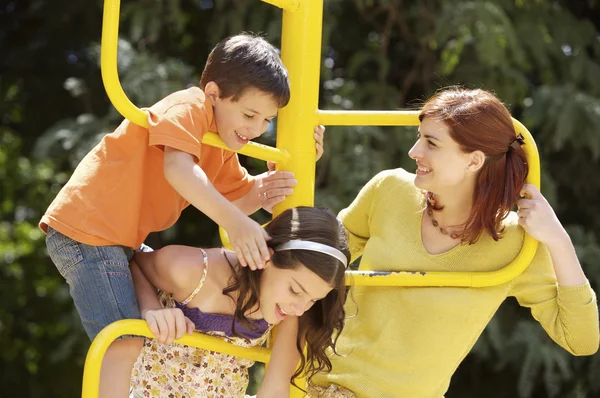 Mãe e crianças no parque infantil — Fotografia de Stock