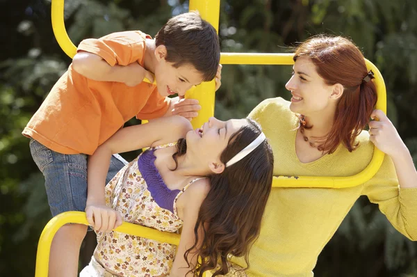 Madre e hijos en el parque infantil —  Fotos de Stock