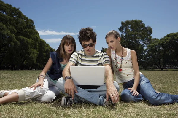 Three teenagers with laptop — Stock Photo, Image