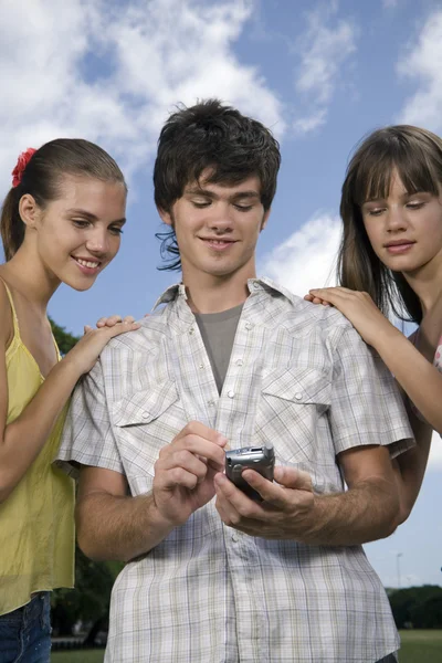 Teenageři, při pohledu na mobilní telefon — Stock fotografie