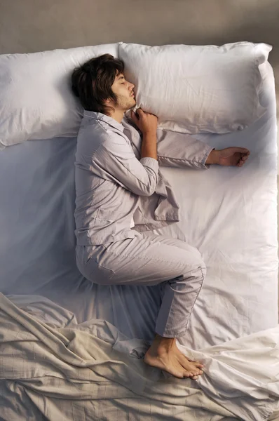 Joven hombre durmiendo en la cama — Foto de Stock