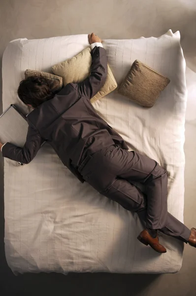 Молодой человек спал с чемоданом — стоковое фото