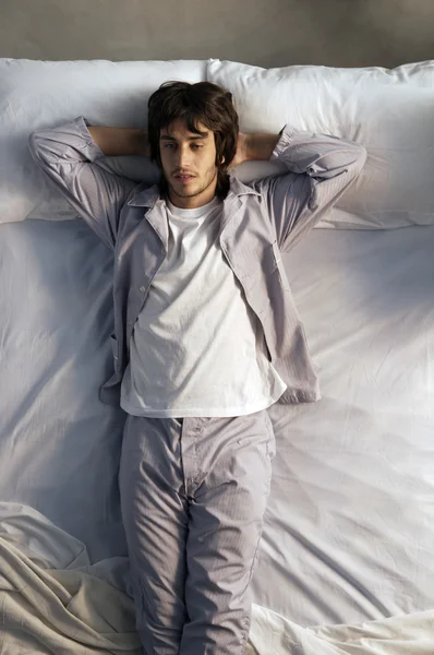 Młody mężczyzna leży w łóżku. — Zdjęcie stockowe