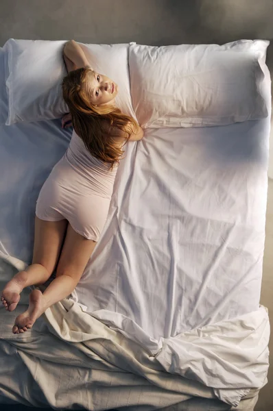 Jovem mulher deitada na cama — Fotografia de Stock