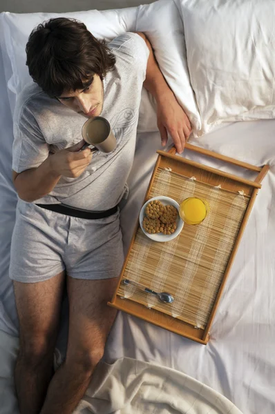 Hombre desayunando en la cama — Foto de Stock