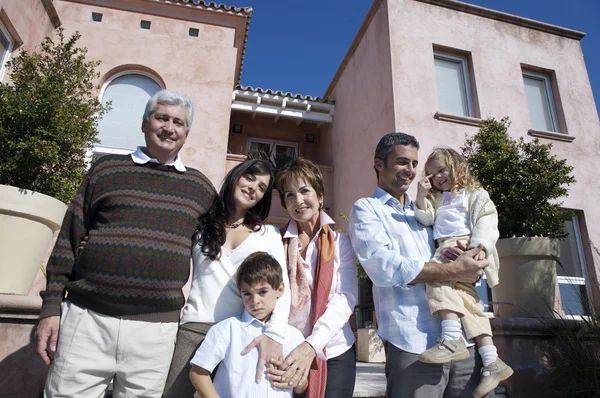 family standing against pink house