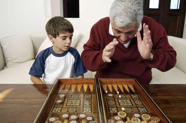 Dědeček a vnuk hrát vrhcáby — Stock fotografie