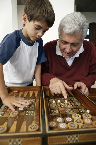 Nagyapa és unokája moziban vagy Backgammon játékkal — Stock Fotó