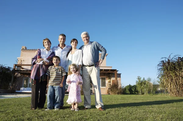 Family standing on green lawn — Stock Photo, Image