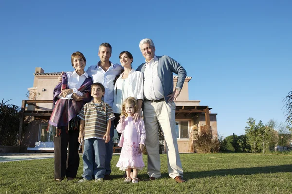 Family standing on green lawn — Stock Photo, Image
