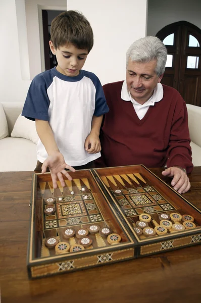 Grand-père et petit-fils jouant au backgammon — Photo