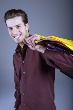 Alışveriş çantalı genç adam.