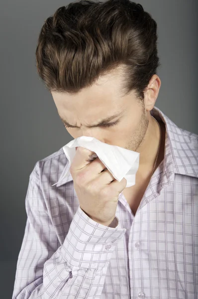 Young man sneezing — Stock Photo, Image