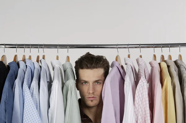 Человек в рядах разных рубашек — стоковое фото
