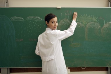 Öğretmen tahtaya yazı yazıyor