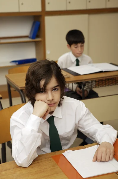 Verveeld schooljongen aan de balie — Stockfoto