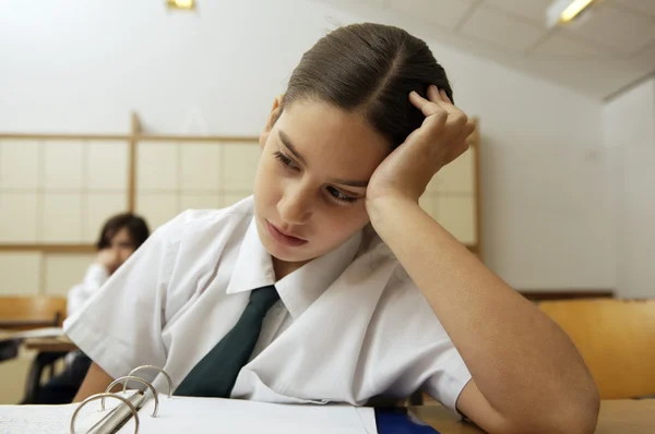 Bored schoolgirl at the desk — Stock Photo, Image