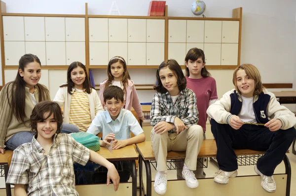 Schoolgaande kinderen poseren in de klas — Stockfoto