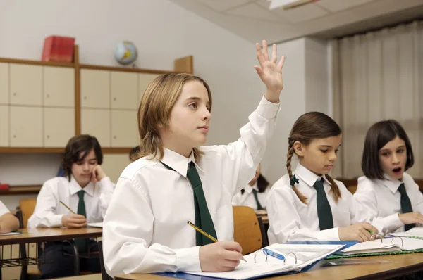 Adorable colegial inteligente levantando la mano —  Fotos de Stock