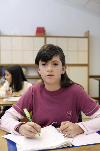 Chica de la escuela sentada junto al escritorio —  Fotos de Stock