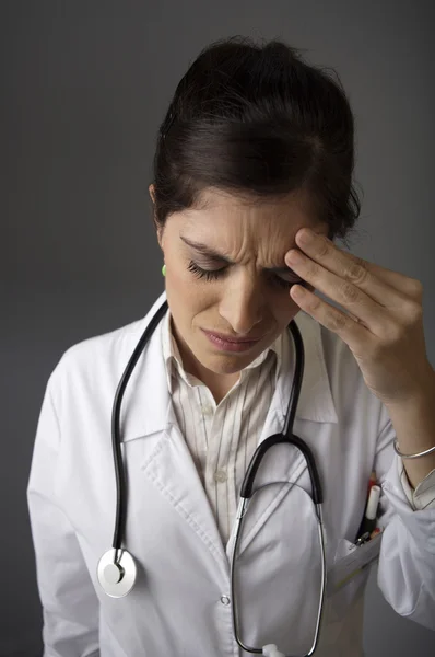 Женщина-врач с головной болью — стоковое фото