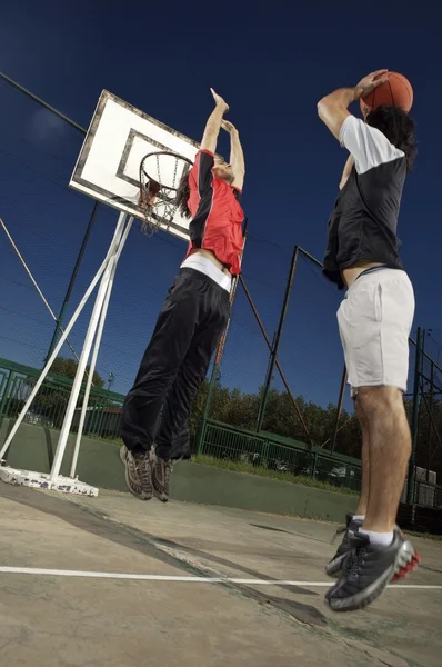 Unga män som spelar basket — Stockfoto