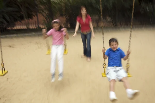 Madre e hijos en el parque infantil — Foto de Stock