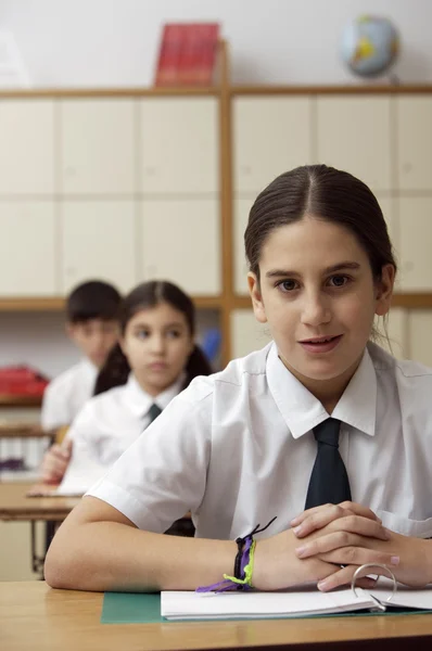 School meisje zit aan de balie — Stockfoto