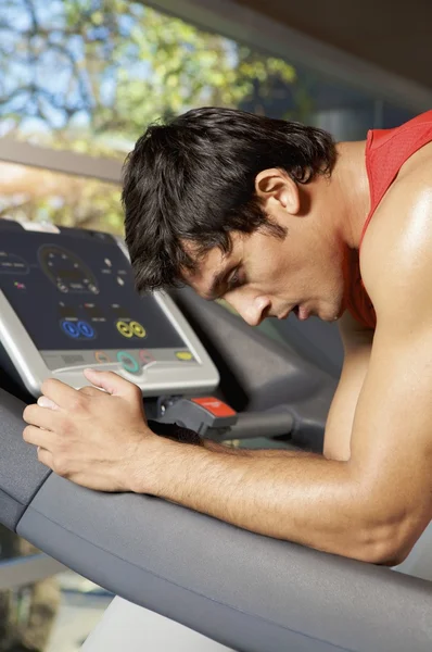 Young man leaning on treadmill — Stock Photo, Image