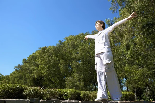 An elderly woman stretching — Stock Photo, Image