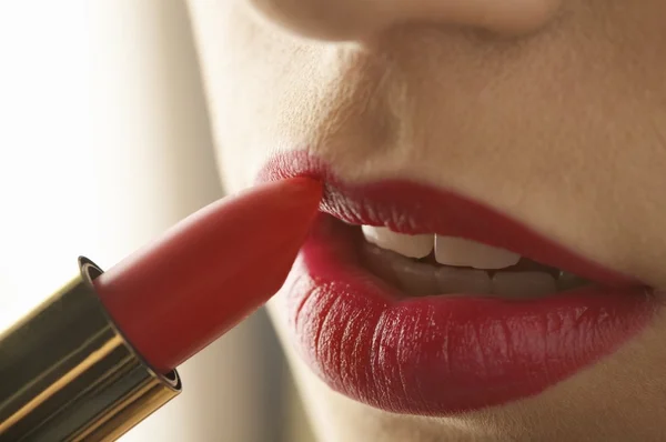 Vrouw die rode lippenstift aanbrengt — Stockfoto