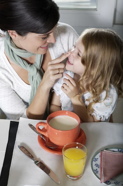 Madre e hija sentadas a la mesa — Foto de Stock