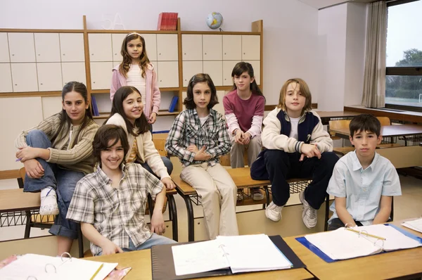 Niños en edad escolar posando en clase — Foto de Stock