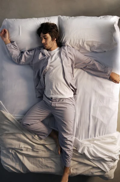 Joven hombre durmiendo en la cama — Foto de Stock