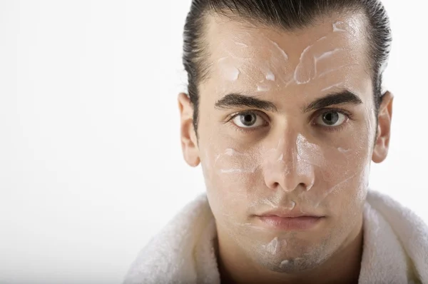 Man met lotion op zijn gezicht — Stockfoto
