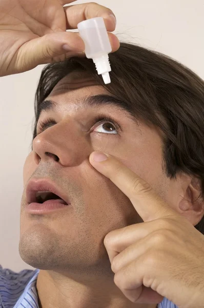 Nemocný muž upustí kapky do očí — Stock fotografie
