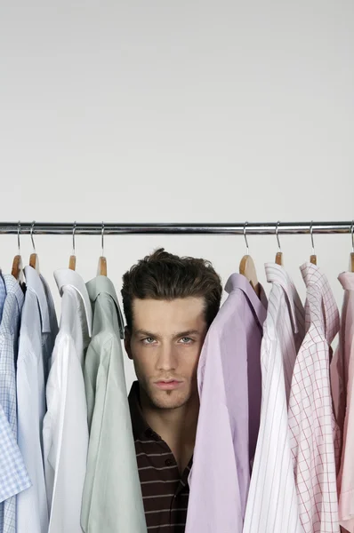 Mannen i raden av olika tröjor — Stockfoto