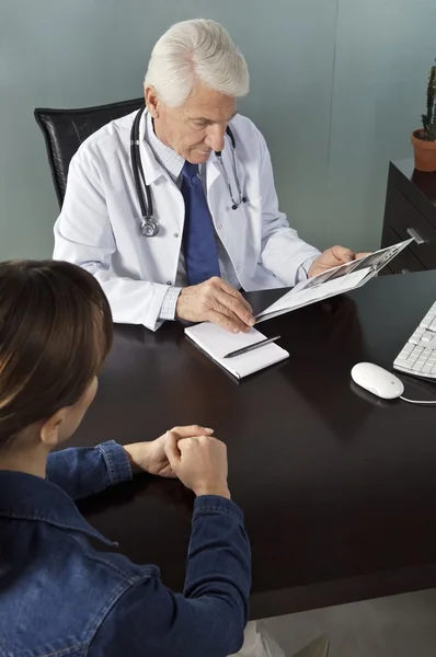 Médico trabajando con paciente en consultorio — Foto de Stock