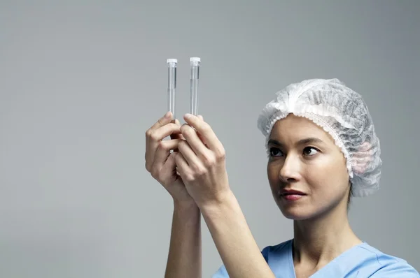 Kadın doktor bakarak tüpler testleri — Stok fotoğraf