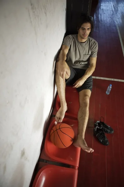 Jugador de baloncesto sentado en el gimnasio —  Fotos de Stock